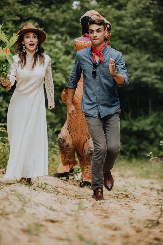 a bride and groom run away from a trex